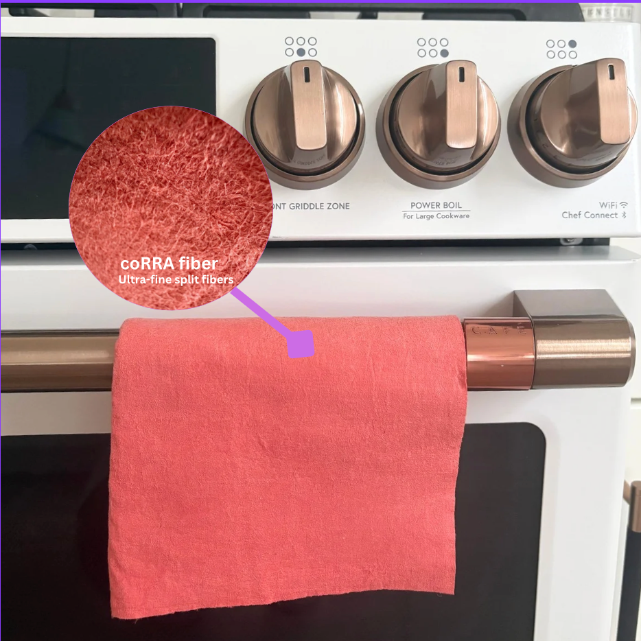 Red towel hanging on a stove handle with a close-up of CORRA fiber material.
