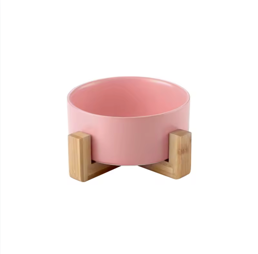 Pink bowl with wooden base on a white background